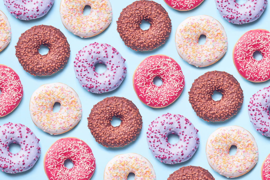 Various colorful donuts with different toppings on a blue background.