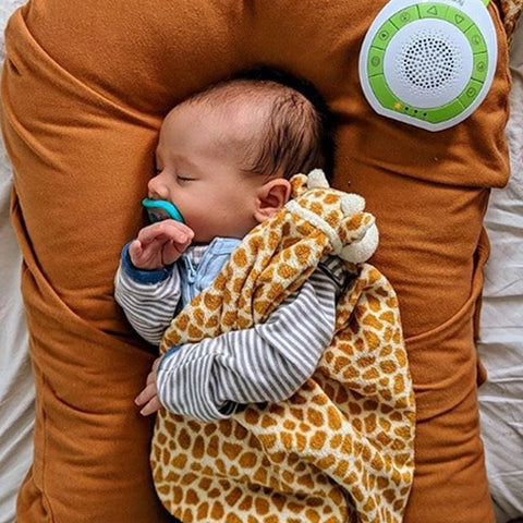 Sleeping baby with giraffe print blanket