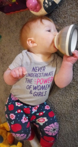 Baby girl self-feeding from nanobebe bottle