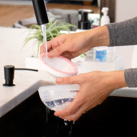 Cleaning nanobébé pink Breastmilk Bottle in sink.