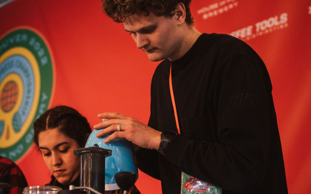 Competitor pouring with the Brewista Artisan Gooseneck Kettle on stage.