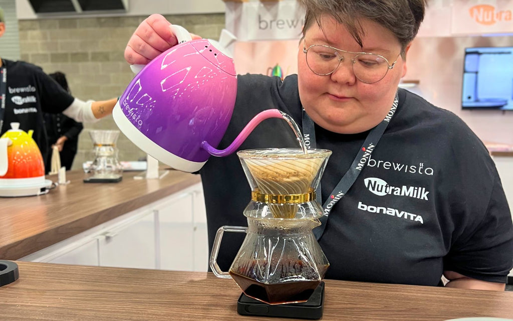 Caitlin Campbell is pouring water out of the Limited Edition Artisan Gooseneck Kettle in Candy Purple to make pour over coffee.