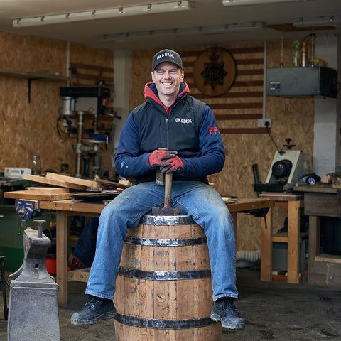 Oak and Black managing director Freddie Main sitting on one of his barrel bars