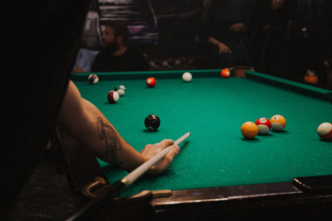 Man playing pool on a green pool table