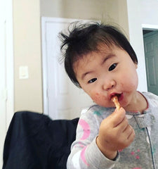 El bebé disfruta de su comida con la cara sucia