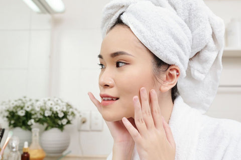 women applying skin brightening cream after shower 