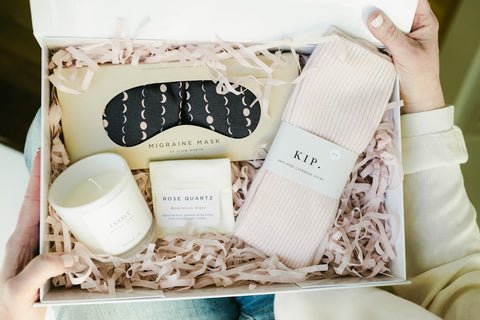 beautiful gift box including cashmere socks, candle, migraine mask and meditation stone