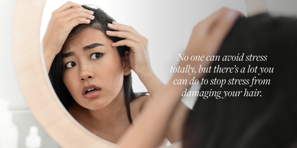 woman looks at grey hair in mirror