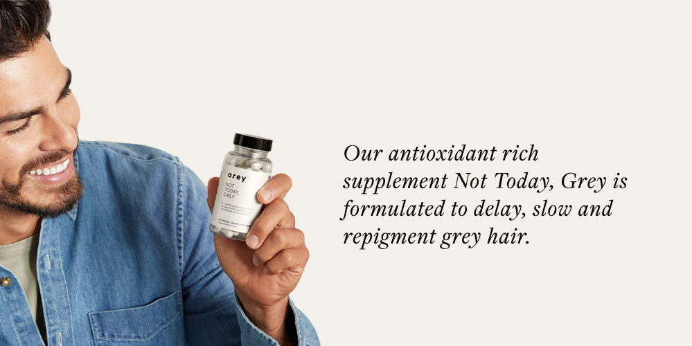 smiling man holding bottle of supplements