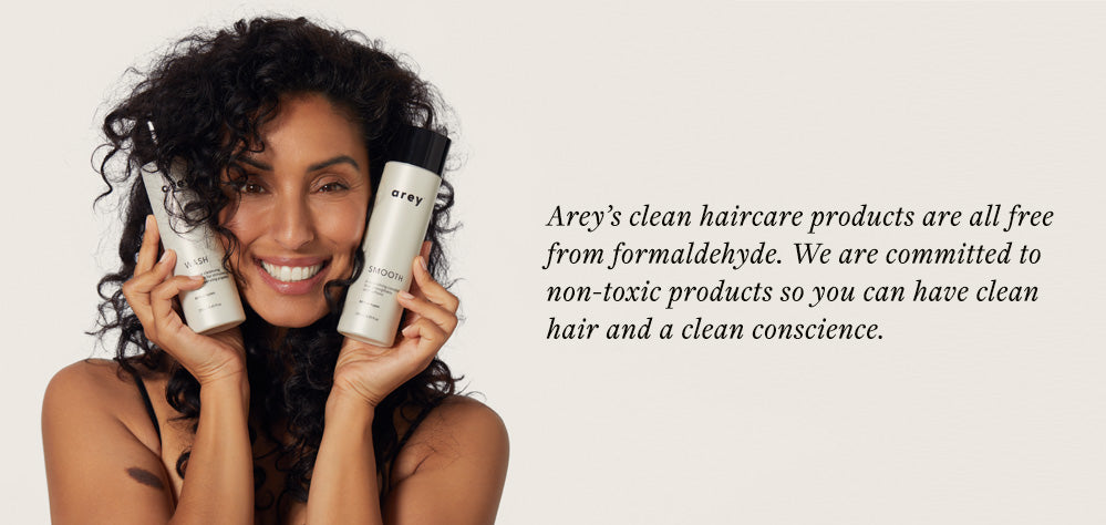 Woman holding Arey clean, non-toxic shampoo and conditioner