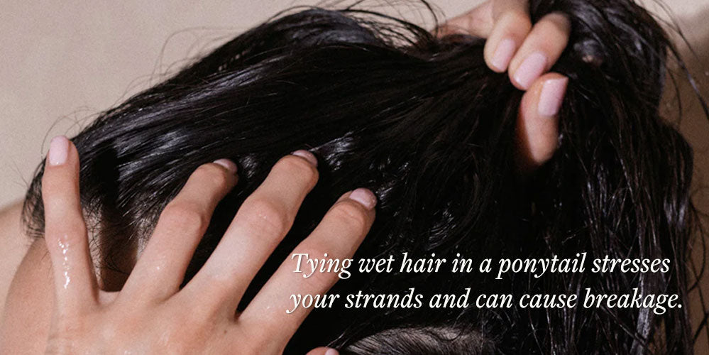 woman putting wet hair in a ponytail