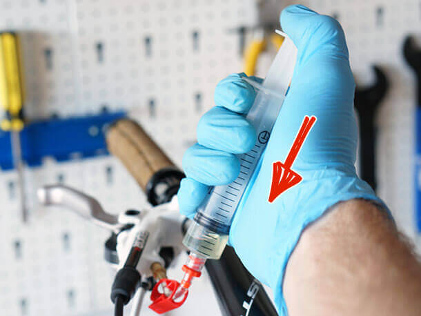 pushing down on avid master cylinder bleed syringe