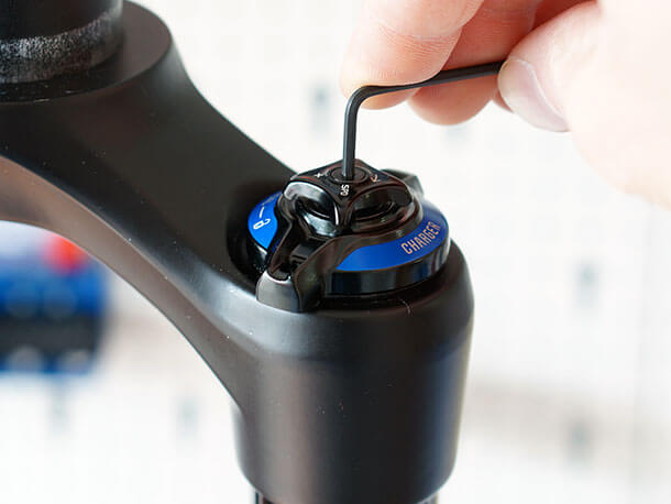 Removing the low speed adjuster knob screw of black RockShox Pike RCT3 suspension fork