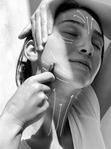 Using stainless steel gua sha to contour facial features such as jawline and cheek bones.