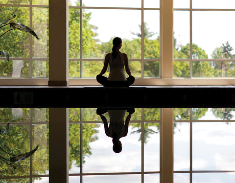 Woman sitting criss cross at a luxurious spa retreat