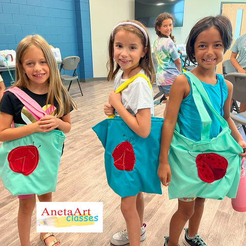 Girls are showing their beautiful tote bags with lady bugs