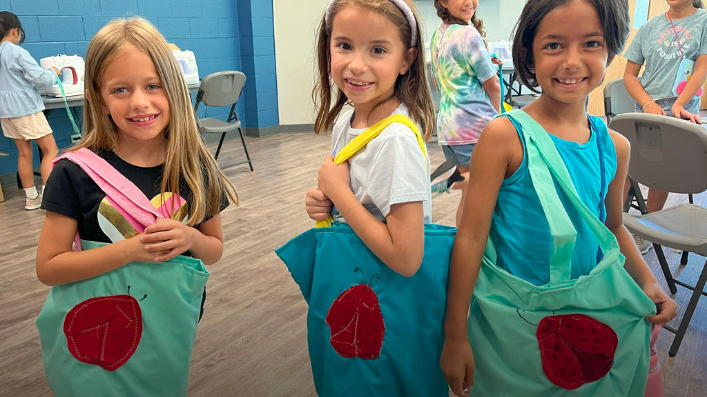 Thre girls are showing there beautiful tote bags from our kids sewing class in Schaumburg