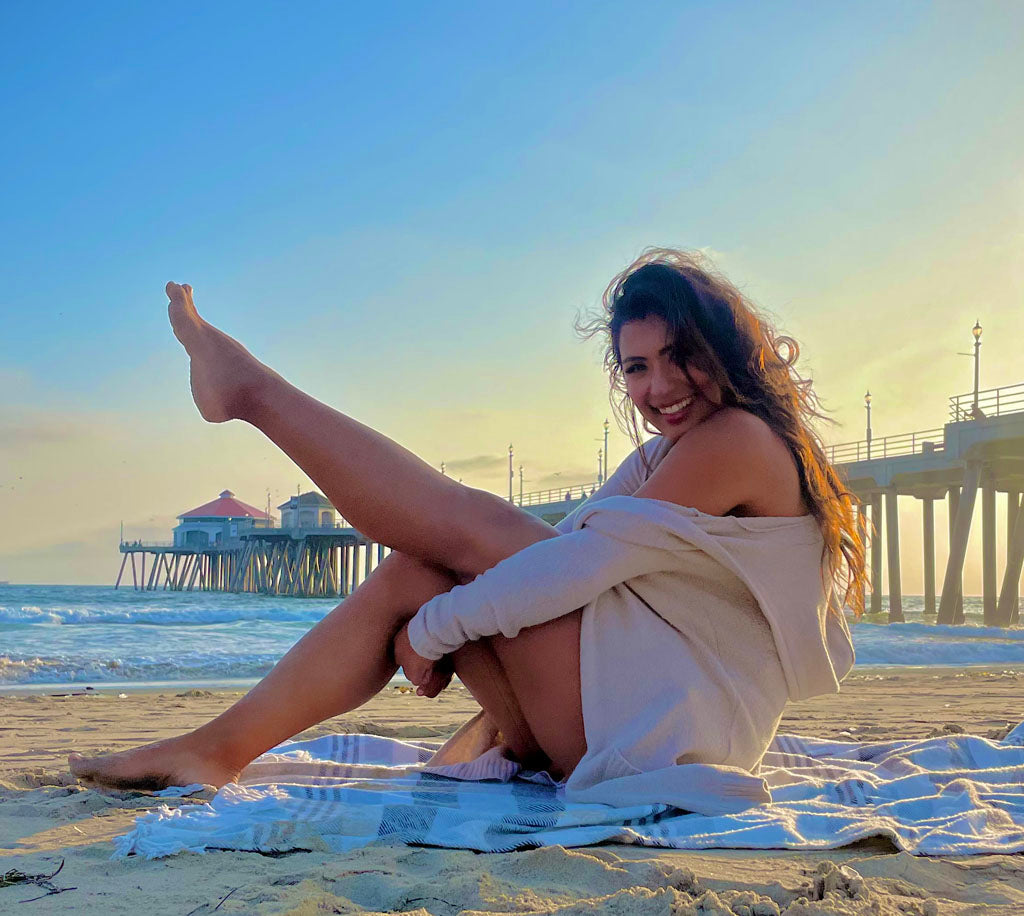 Kelly Ruiz on a beach near a pier