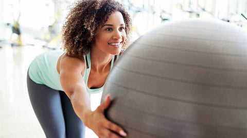 swiss-ball-femme-assise-sourirante-etirement