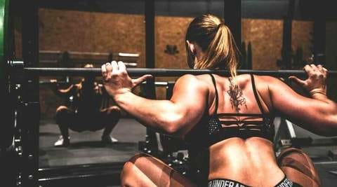 femme-squat-complet-salle-de-fitness