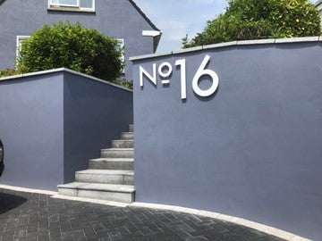 Grey rendered wall with large laser cut white giant digit sign