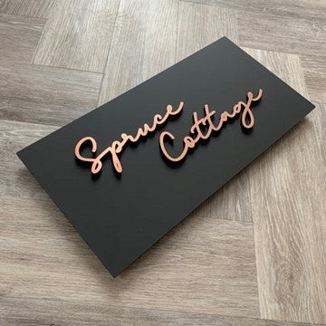 Black rectangular House Name Sign with 3D cursive copper writing.