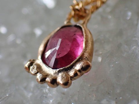 Gold and garnet pendant atop a crystal 