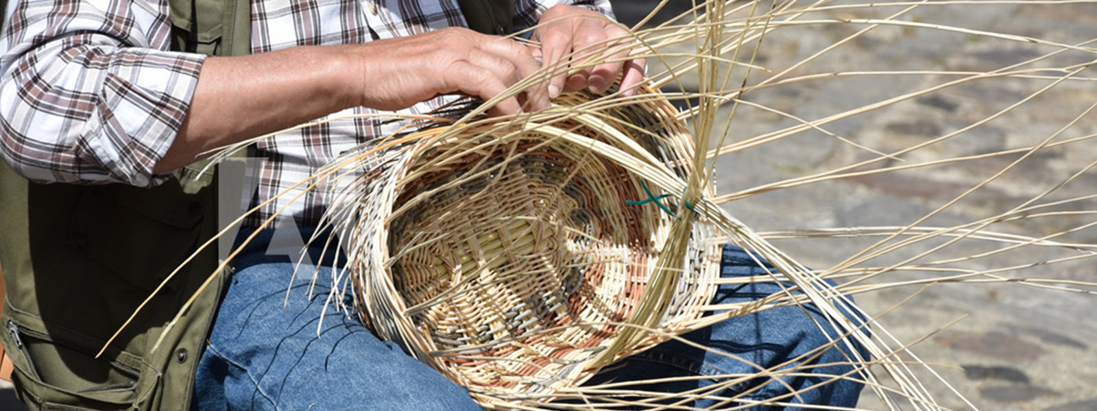 artisan vannier fabriquant un panier en osier