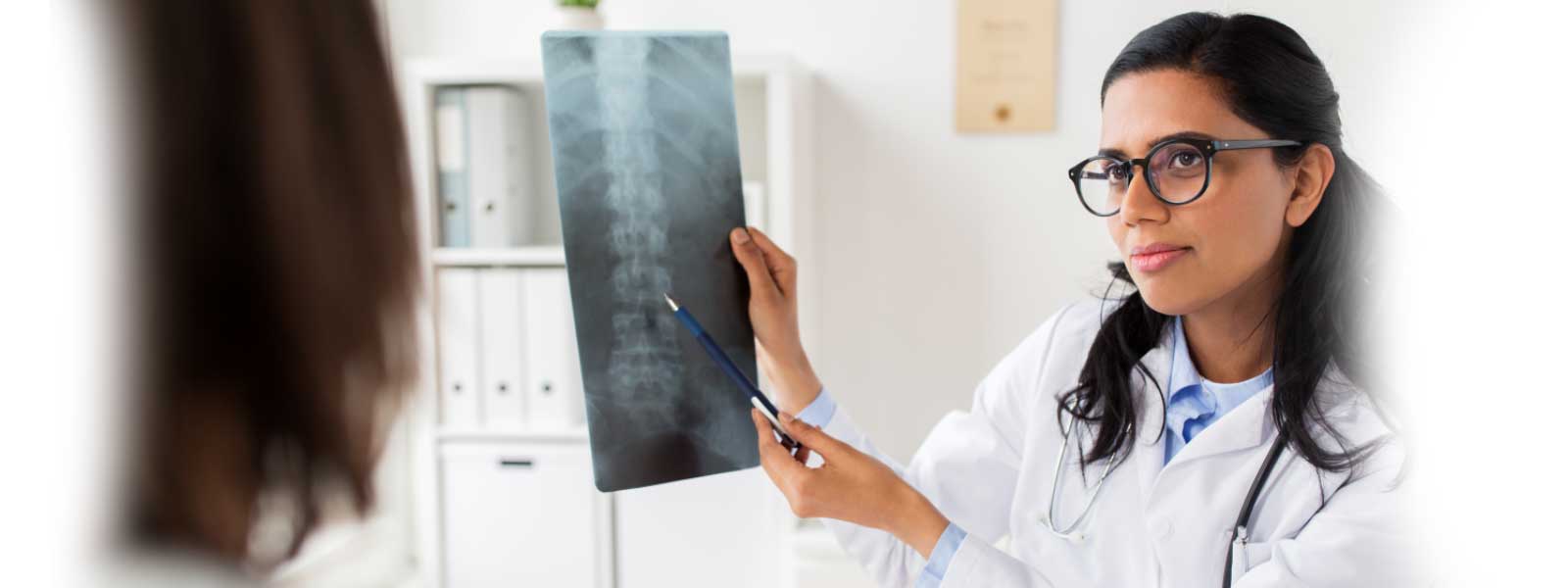 docteur montrant une radiographie de la colonne vertébrale