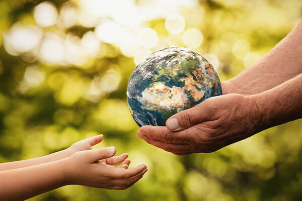 Homme qui transmet une petite planète à un enfant dans ses mains