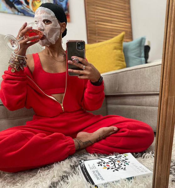 women putting on face mask and drinking wine