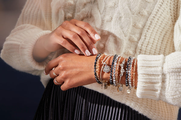 woman wearing a stack of ALEX AND ANI family bracelets