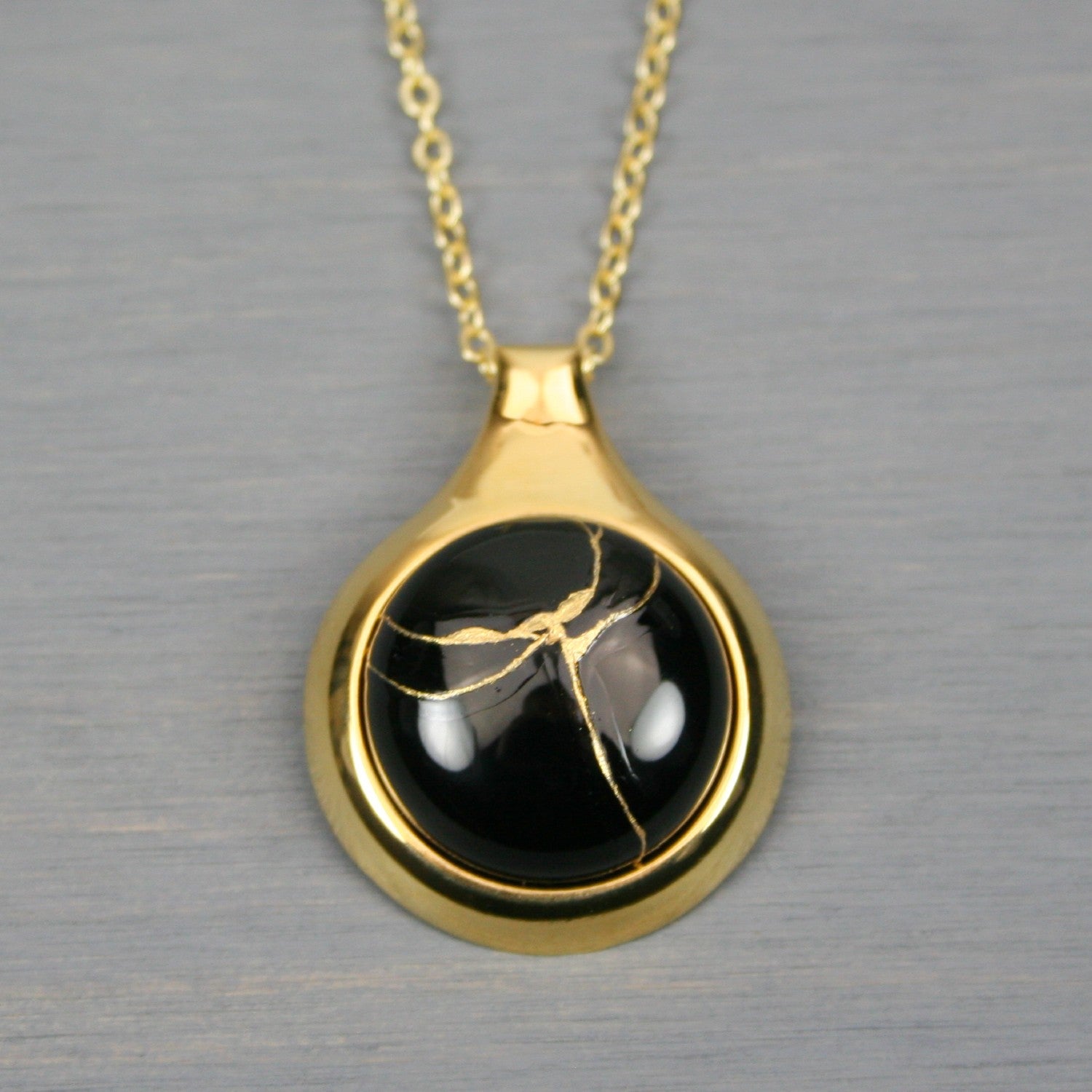 Black onyx kintsugi pendant in a gold setting on chain