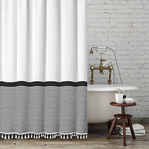 Black and white striped shower curtain with tassels, adding modern style to bathroom decor.