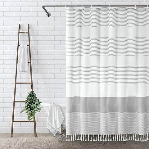 Gray shower curtain with tassels, adding elegance to bathroom decor.