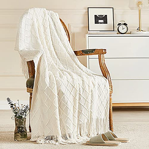 Off-white knitted throw blanket with diamond pattern and tassels, ideal for bohemian home decor.