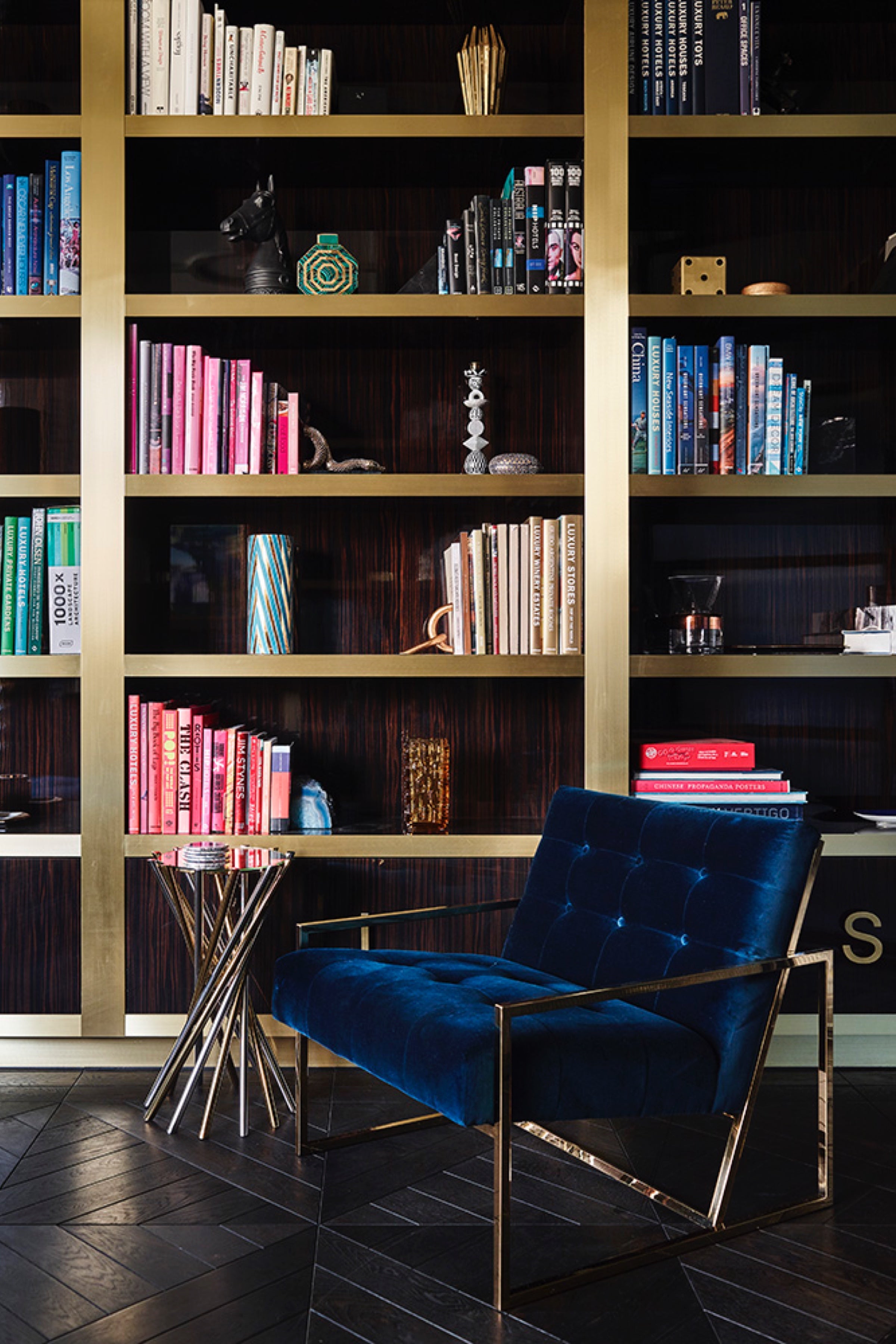 Blue and gold chair in front of bookcase
