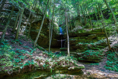 Waterfall steaming over off trail cave opening in Conkles hollow state nature preserve in Hocking county Ohio 