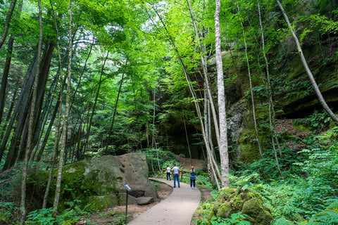 Hiking past rock shelters and caves within Conkles hollow state nature preserve in Hocking county Ohio 