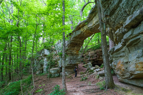 Front view of hiker standing inside of Sewanee Natural Bridge Arch in Tennessee 