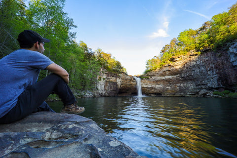 Hiker sitting in front of scenic waterfall and canyon of DeSoto Falls Picnic Area in northeast Alabama 