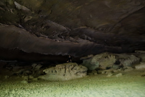 hiker standing on massive boulders inside Hazard Cave in Pickett CCC State Park