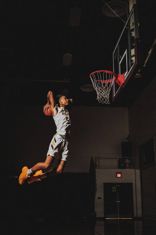 man playing basketball slam dunk