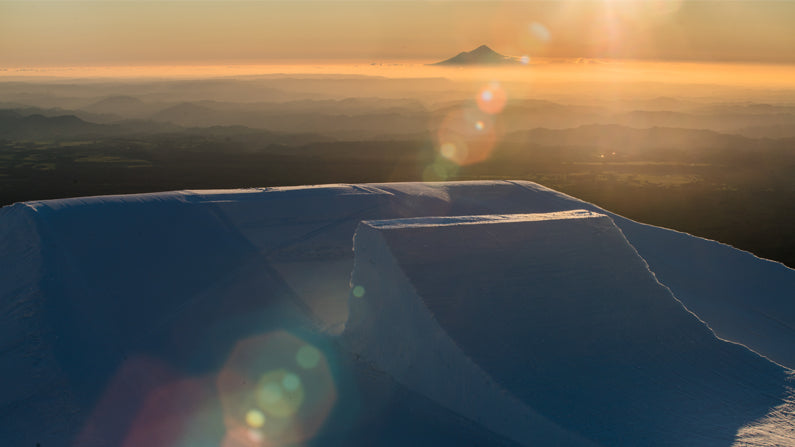 Mammoth Jump up Turoa, Mt Ruapehu with Mt Taranaki in the background. Photo taken by Team Opus member Nick Love for Left Turn Right Productions. Opus Fresh New Zealand Made Merino Apparel.