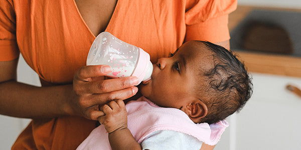 Baby drinking baby formula from bottle