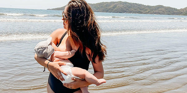 Mom breastfeeding on the beach