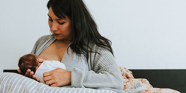 Mom breastfeeding baby in bed