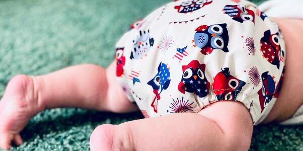 A baby wearing a cloth diaper crawling