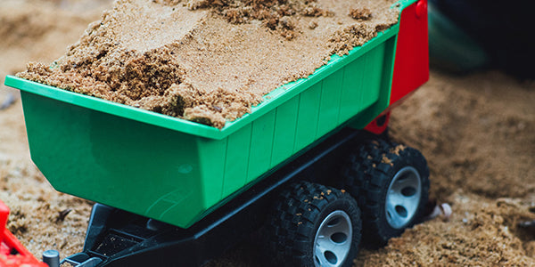 Kid's toy dump truck filled with sand