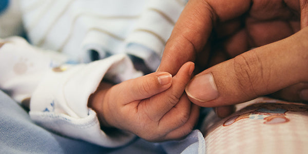 Newborn's hand with long nails